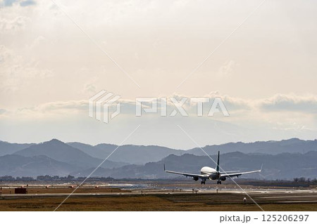 夕暮れの仙台空港　着陸中の飛行機　宮城県名取市 125206297