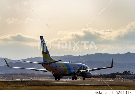夕暮れの仙台空港　離陸中の飛行機　宮城県名取市 125206318