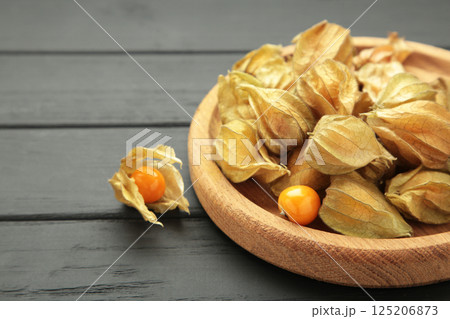 Physalis peruviana fruit on black wooden background. Physalis peruviana fruit on black wooden background. 125206873