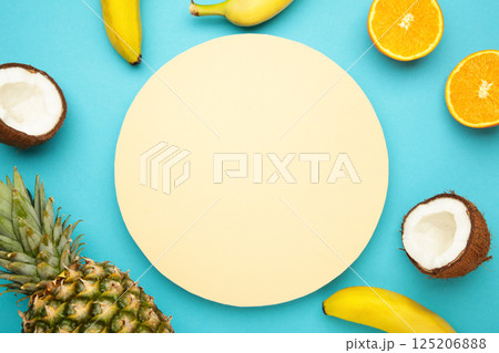 Tropical fruits. Pineapple, coconut, orange and banana on blue background. Space for text Tropical fruits. Pineapple, coconut, orange and banana on blue background. Space for text 125206888