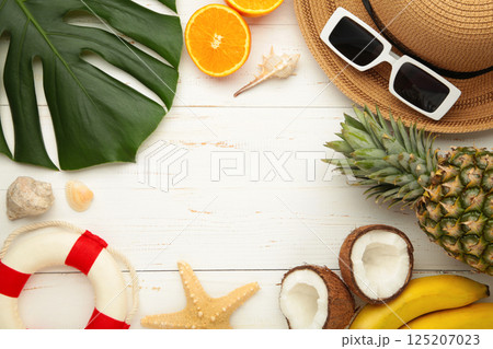 Tropical leaves and fruits, hat, summer concept on white wooden background. Copy space Tropical leaves and fruits, hat, summer concept on white wooden background. Copy space 125207023