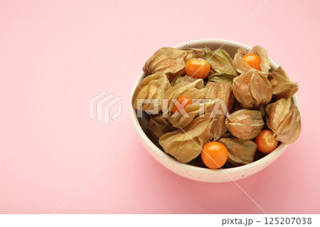 Physalis peruviana fruit on light plate on pink background. Physalis peruviana fruit on light plate on pink background. 125207038