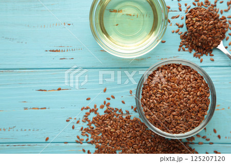 Flax seeds and oil in bottle on blue wooden background 125207120