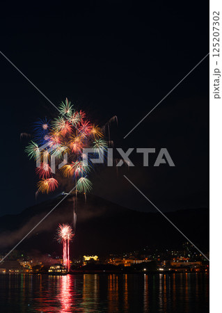 夏の夜、山と街並みに彩られる花火大会 125207302