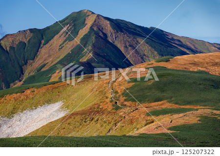 飯豊本山の登りから見る大日岳と縦走路を行く登山者 125207322