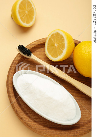 Toothbrush with lemon and baking soda on beige background. Vertical photo 125207352