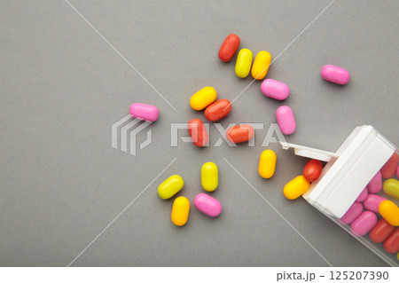 Tasty colored fruit dragee candies with box on grey background. 125207390