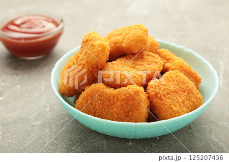 Chicken nuggets with ketchup on plate on grey background. 125207436