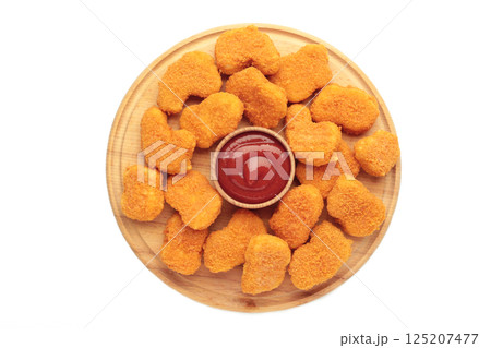 Chicken nuggets with ketchup on cutting board isolated on white background. Chicken nuggets with ketchup on cutting board isolated on white background. 125207477