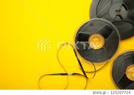 Film reel on yellow background. Space for text 125207724