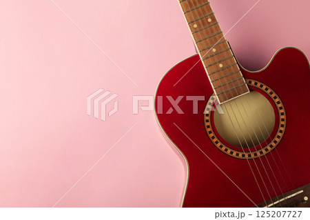 Detail of red guitar on pink background. Space for text Detail of red guitar on pink background. Space for text 125207727