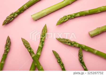 Fresh green asparagus on pink background. Healthy food concept. Vegan healthy food. Top view Fresh green asparagus on pink background. Healthy food concept. Vegan healthy food. Top view 125207732