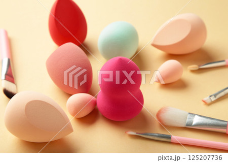 Makeup brush and beauty makeup sponges on beige background. Beauty and makeup concept 125207736