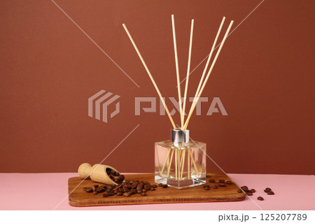 Reed diffuser and coffee beans on brown background. 125207789