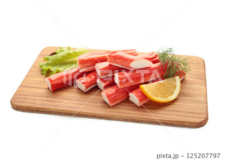 Fresh crab sticks with lemon on cutting board isolated on white background. 125207797