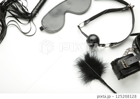 Set of erotic toys for BDSM on white background. The game of sexual slavery with a whip, gag and leather blindfold. Intimate sex games 125208128