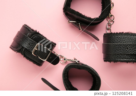 Handcuffs for sex games on pink background. Sexual bdsm toy. Fetish, erotic concept. 125208141