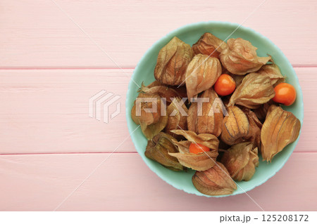 Physalis peruviana fruit on mint plate on pink background. 125208172