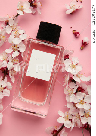 Bottle of woman perfume on pink background with spring apricot and cherry flowers. Bottle of woman perfume on pink background with spring apricot and cherry flowers. 125208177