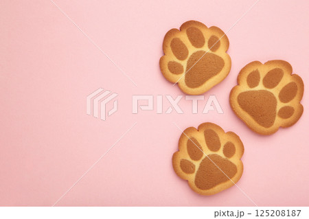 Self made cat paw cookies on pink background. Self made cat paw cookies on pink background. 125208187