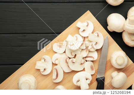 Fresh white champignon mushrooms on cutting board. Space for text 125208194