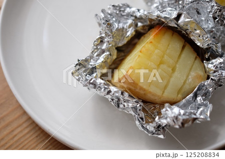 アルミホイルに包まれたじゃがバター アルミホイルに包まれたじゃがバター 125208834