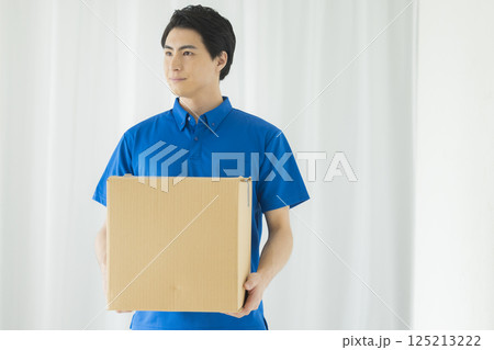 荷物を運ぶ笑顔の男性　 125213222