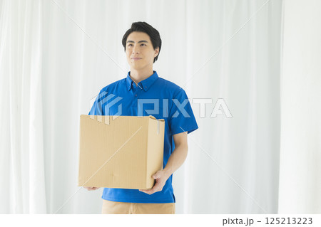 荷物を運ぶ笑顔の男性　 125213223