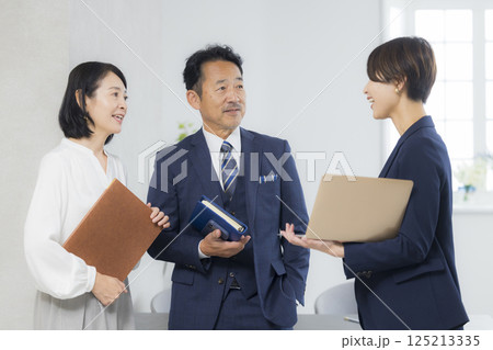 オフィスで打ち合わせをするビジネスマンとビジネスウーマン オフィスで打ち合わせをするビジネスマンとビジネスウーマン 125213335