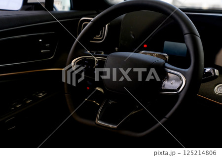 A close-up of a modern car's steering wheel with control buttons A close-up of a modern car's steering wheel with control buttons 125214806