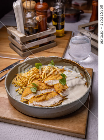 Breaded chicken breast with white sauce Breaded chicken breast with white sauce 125215569