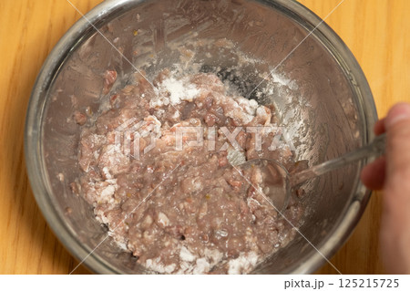 真いわしに卵白と小麦粉を加えて混ぜているところ (写真素材) 真いわしに卵白と小麦粉を加えて混ぜているところ (写真素材) 125215725