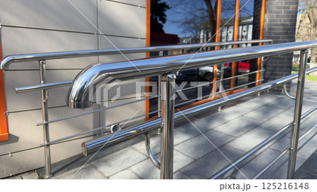 Handrails for grabbing when climbing ramp for people with disabilities. Creating comfortable entrance with care for people with mobility problems. Ramp for strollers and wheelchairs Handrails for grabbing when climbing ramp for people with disabilities. Creating comfortable entrance with care for people with mobility problems. Ramp for strollers and wheelchairs 125216148