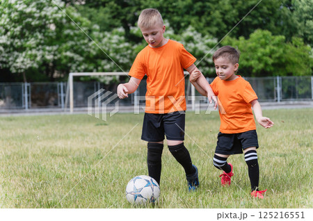 Two boys fighting for ball during outdoor soccer game. 125216551