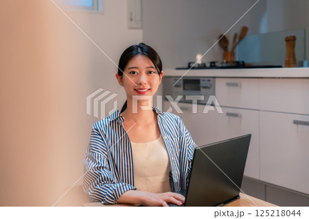 夜遅くまで在宅勤務をする若い女性 夜遅くまで在宅勤務をする若い女性 125218044