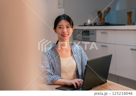夜遅くまで在宅勤務をする若い女性 夜遅くまで在宅勤務をする若い女性 125218046