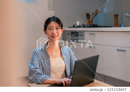 夜遅くまで在宅勤務をする若い女性 夜遅くまで在宅勤務をする若い女性 125218047