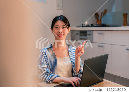 夜遅くまで在宅勤務をする若い女性 125218050