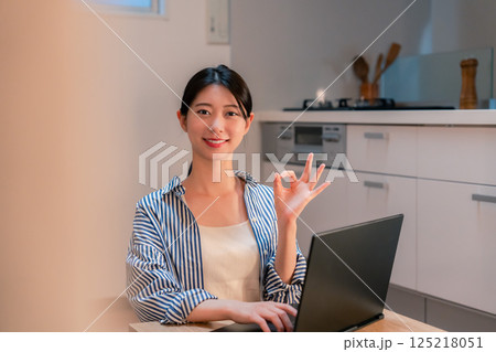 夜遅くまで在宅勤務をする若い女性 夜遅くまで在宅勤務をする若い女性 125218051