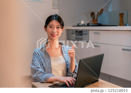 夜遅くまで在宅勤務をする若い女性 夜遅くまで在宅勤務をする若い女性 125218053