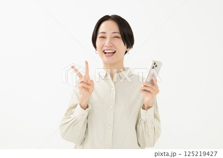 笑顔でスマートフォンを持つ女性 笑顔でスマートフォンを持つ女性 125219427