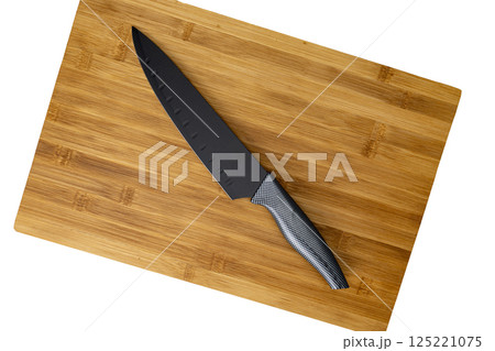 Black Knife on Bamboo Cutting Board on white background 125221075