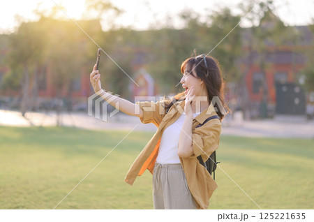 Traveler asian woman in her 30s explores the Grand Palace with a local guide. Uncover hidden gems and immerse yourself in Thai culture with her adventure. 125221635