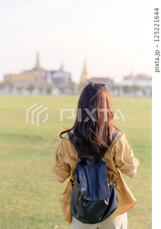 A Traveler Asian woman in her 30s exploring Wat Pra Kaew. From stunning architecture to friendly locals, she cherishes every moment, capturing it all in her heart and camera for years to come. A Traveler Asian woman in her 30s exploring Wat Pra Kaew. From stunning architecture to friendly locals, she cherishes every moment, capturing it all in her heart and camera for years to come. 125221644