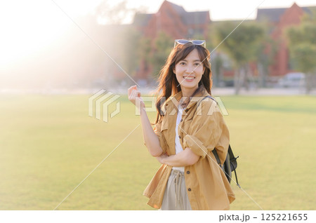 Traveler asian woman in her 30s stands bathed in the golden glow of sunset, embracing the freedom of exploration. on summer holiday weekend vacation trip in Bangkok, Thailand 125221655