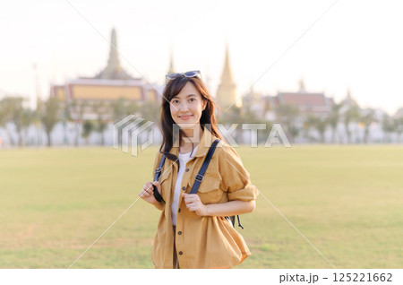 A Traveler Asian woman in her 30s exploring Wat Pra Kaew. From stunning architecture to friendly locals, she cherishes every moment, capturing it all in her heart and camera for years to come. 125221662