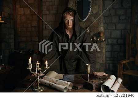 Portrait of hooded serious monk looking at camera with mystic view 125221940