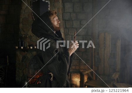 Faithful priest in robe hood praying with rosary beads and cross Faithful priest in robe hood praying with rosary beads and cross 125221964