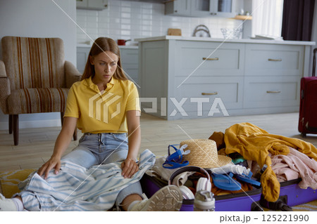 Unhappy woman tourist feeling worried because of clothing excess for travel 125221990