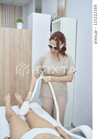 Female technician performing laser hair removal on caucasian adult woman Female technician performing laser hair removal on caucasian adult woman 125222169